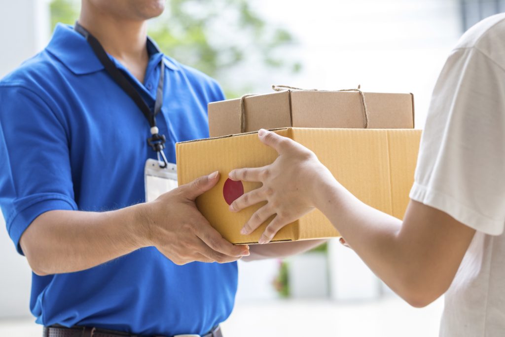 Woman hand accepting a delivery of boxes from deliveryman