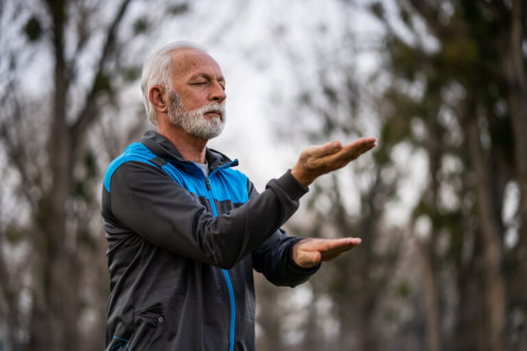 r man is practicing Tai Chi exercise in park.