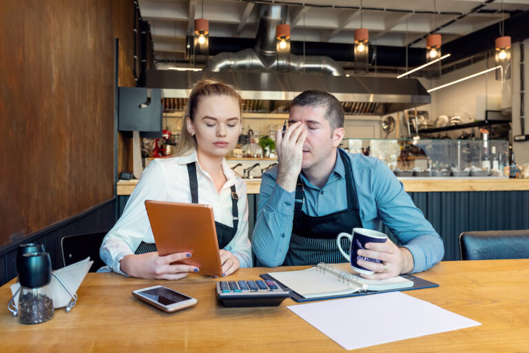 Worried business owners calculating finances